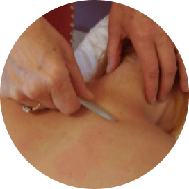 Tracy performing body Gua Sha on clients back