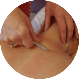 Tracy performing body Gua Sha on clients back