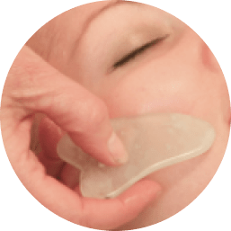 Gua Sha tool on face